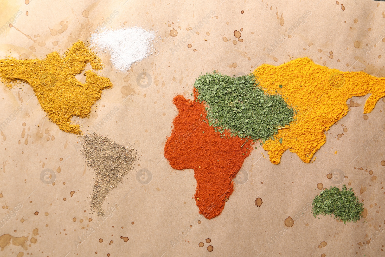 Photo of World map of different spices on old paper, flat lay