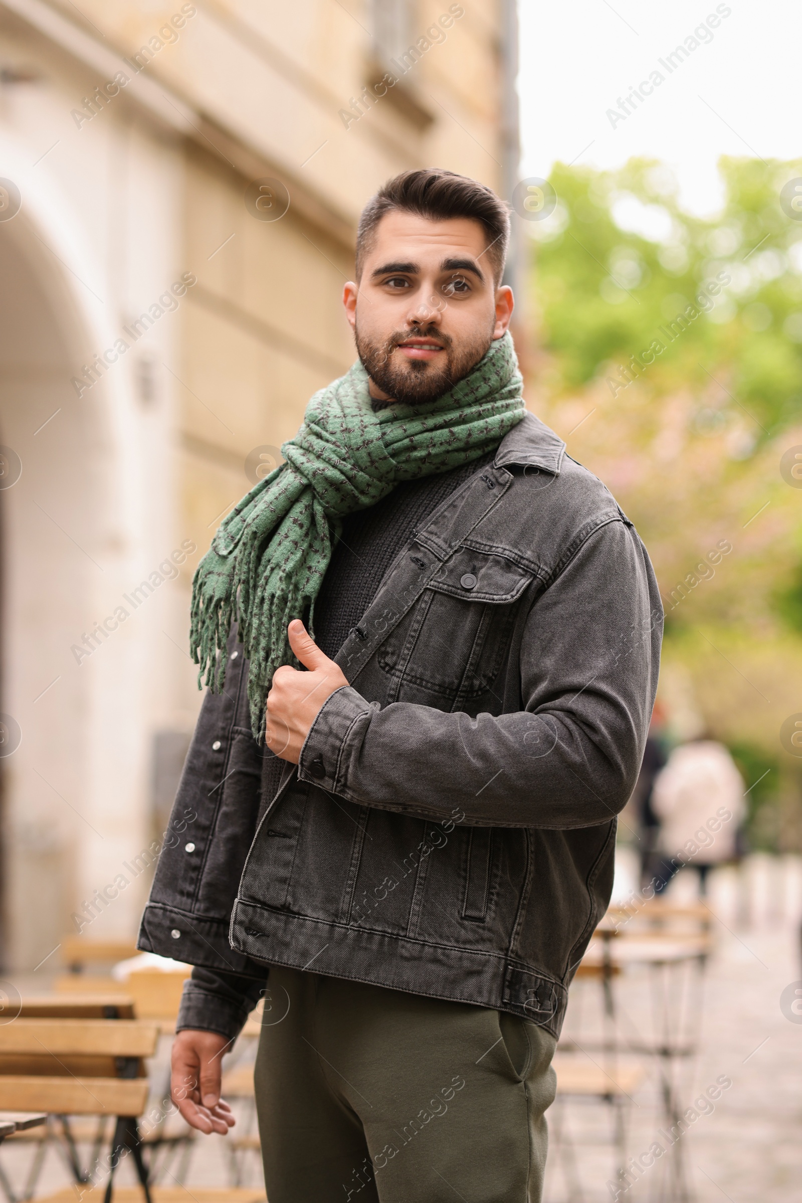 Photo of Handsome man in warm scarf on city street