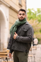 Photo of Handsome man in warm scarf on city street