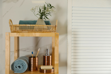 Photo of Shelving unit with toiletries in stylish bathroom interior 