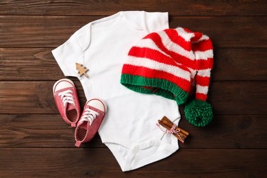 Photo of Flat lay composition with cute Christmas baby clothes on wooden background