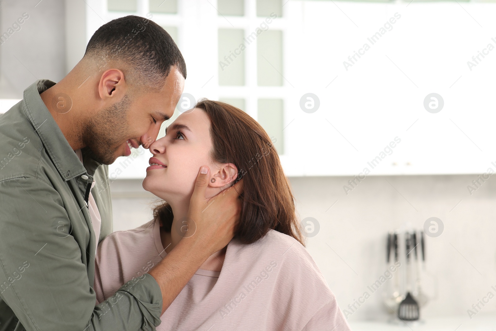 Photo of Dating agency. Happy couple spending time together in kitchen, space for text