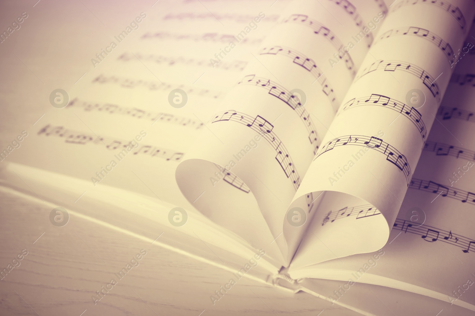 Image of Heart made of book pages with music notes on table, space for text