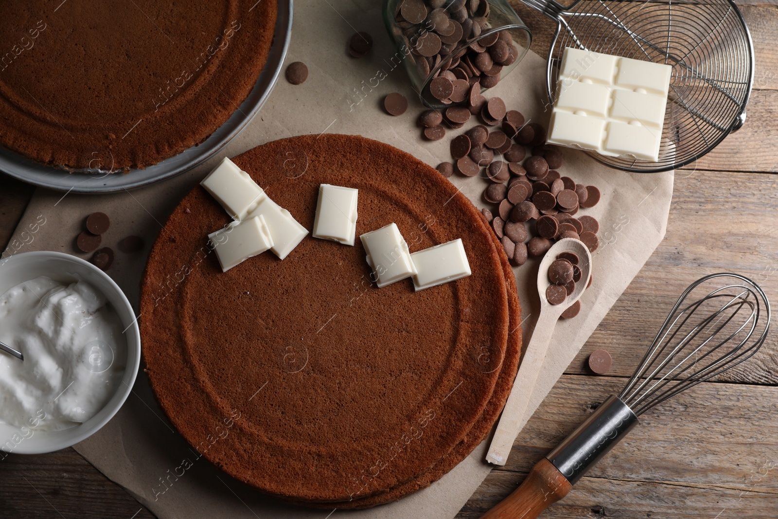 Photo of Ingredients for delicious homemade layer cake preparing on wooden table, flat lay