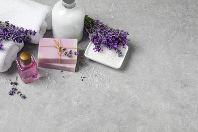 Photo of Cosmetic products and lavender flowers on light table. Space for text