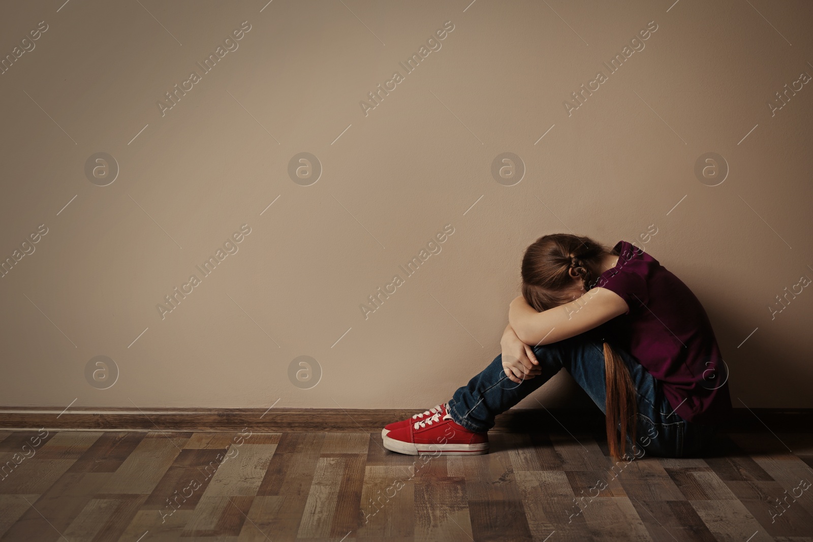 Photo of Little girl on floor indoors, space for text. Child in danger