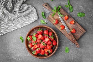 Flat lay composition with ripe red strawberries and mint on grey background