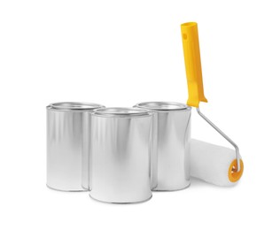 Photo of Cans of paints and roller on white background