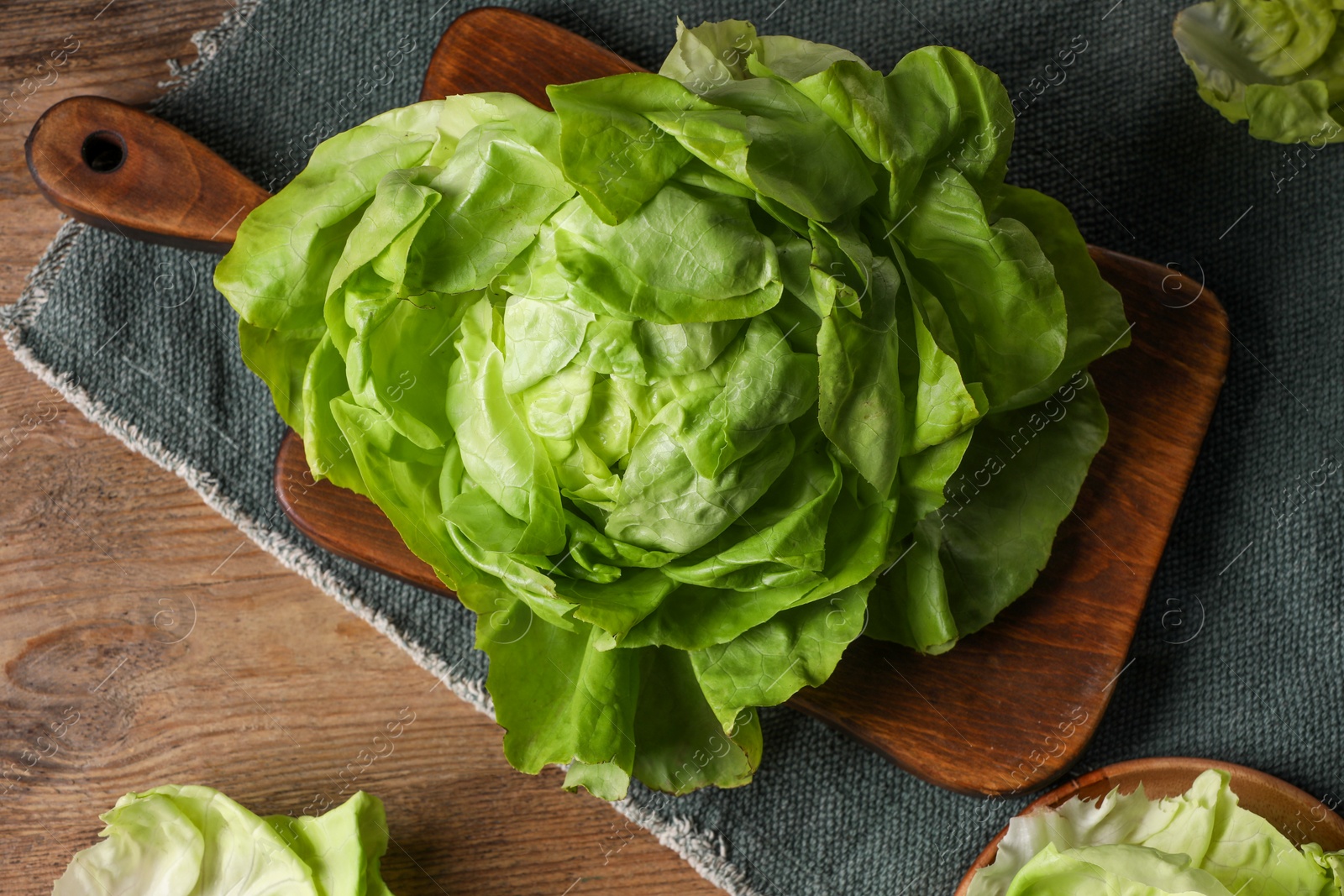 Photo of Fresh green butter lettuce on wooden table, flat lay