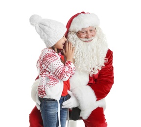 Photo of Little girl whispering in authentic Santa Claus' ear against white background