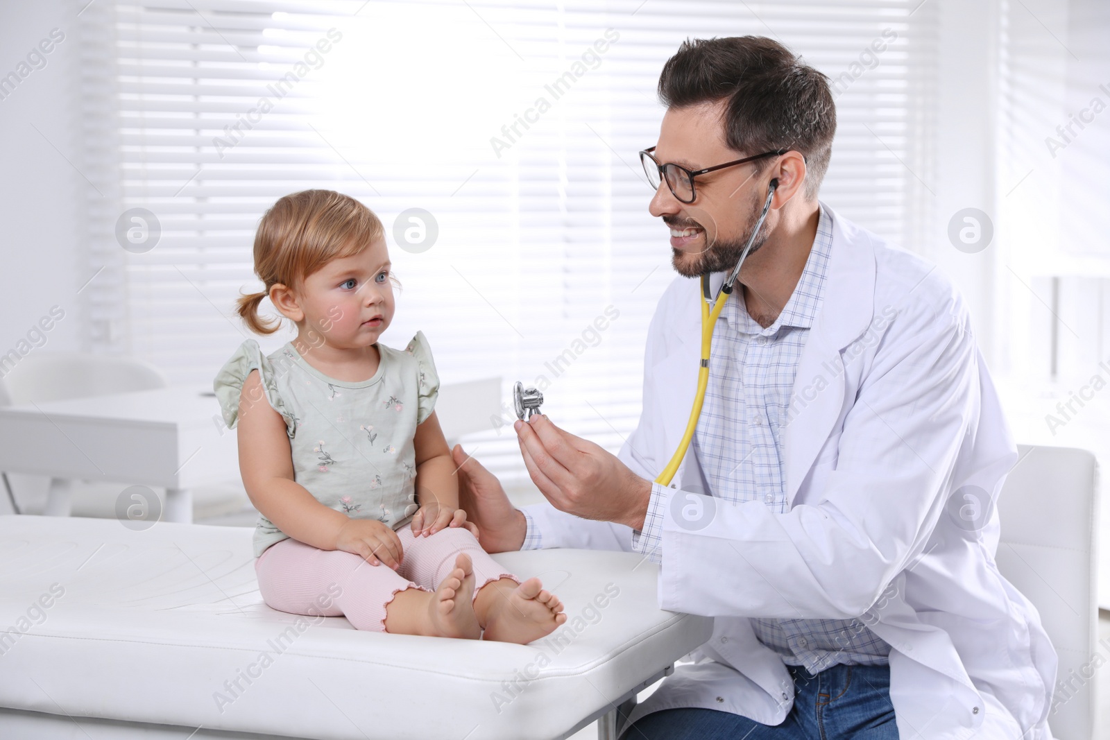 Photo of Pediatrician examining baby with stethoscope in clinic