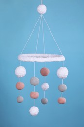 Cute baby crib mobile on light blue background