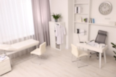 Photo of Blurred view of medical office interior with doctor's workplace