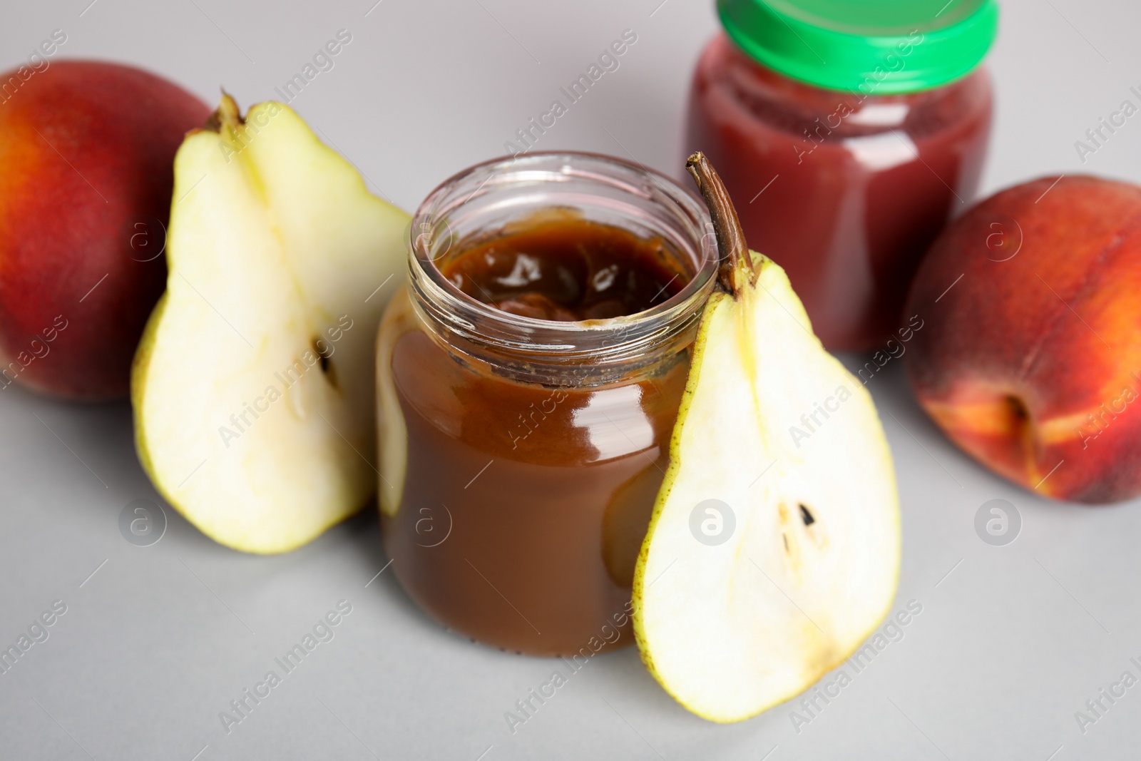 Photo of Healthy baby food and pear on grey background, closeup