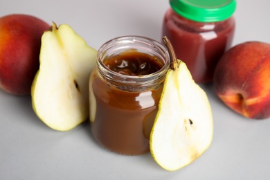 Photo of Healthy baby food and pear on grey background, closeup