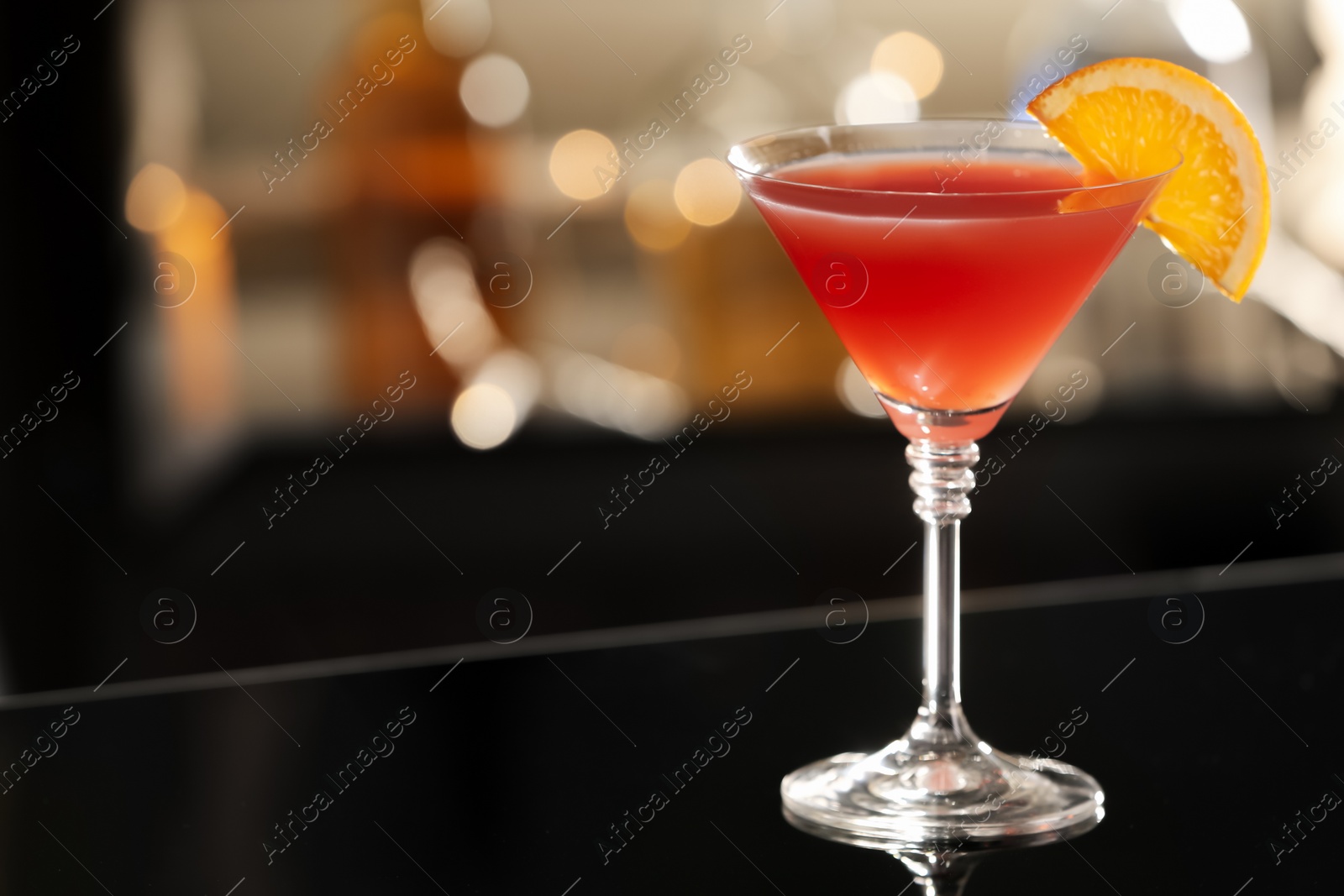 Photo of Delicious cocktail with orange on bar counter. Space for text