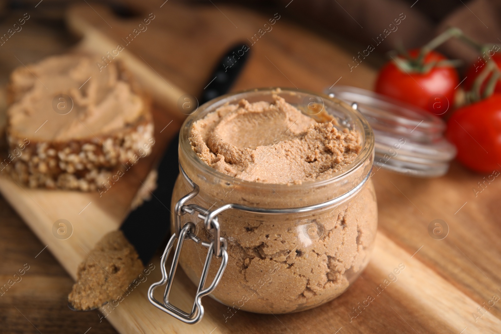 Photo of Delicious meat pate with knife on wooden table, closeup