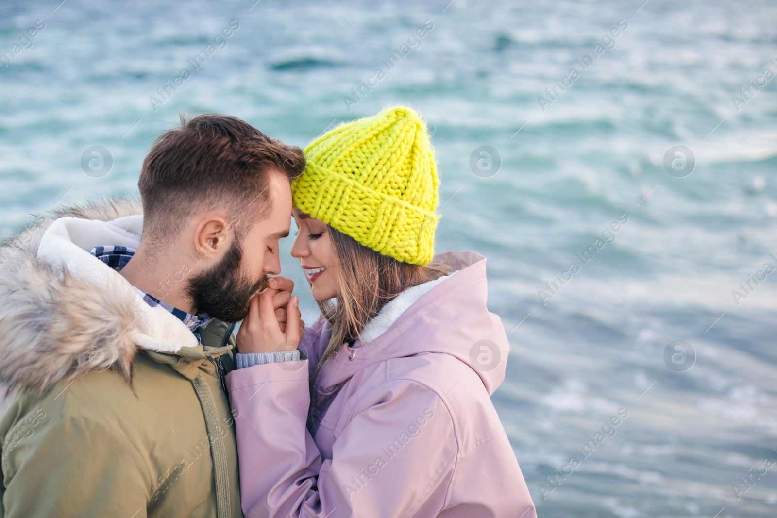 Photo of Lovely young couple near sea. Space for text