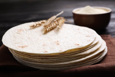 Photo of Stack of tasty tortillas on fabric, closeup