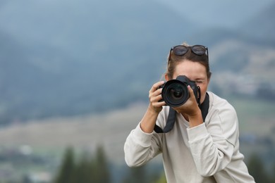 Photo of Photographer working with modern professional camera outdoors
