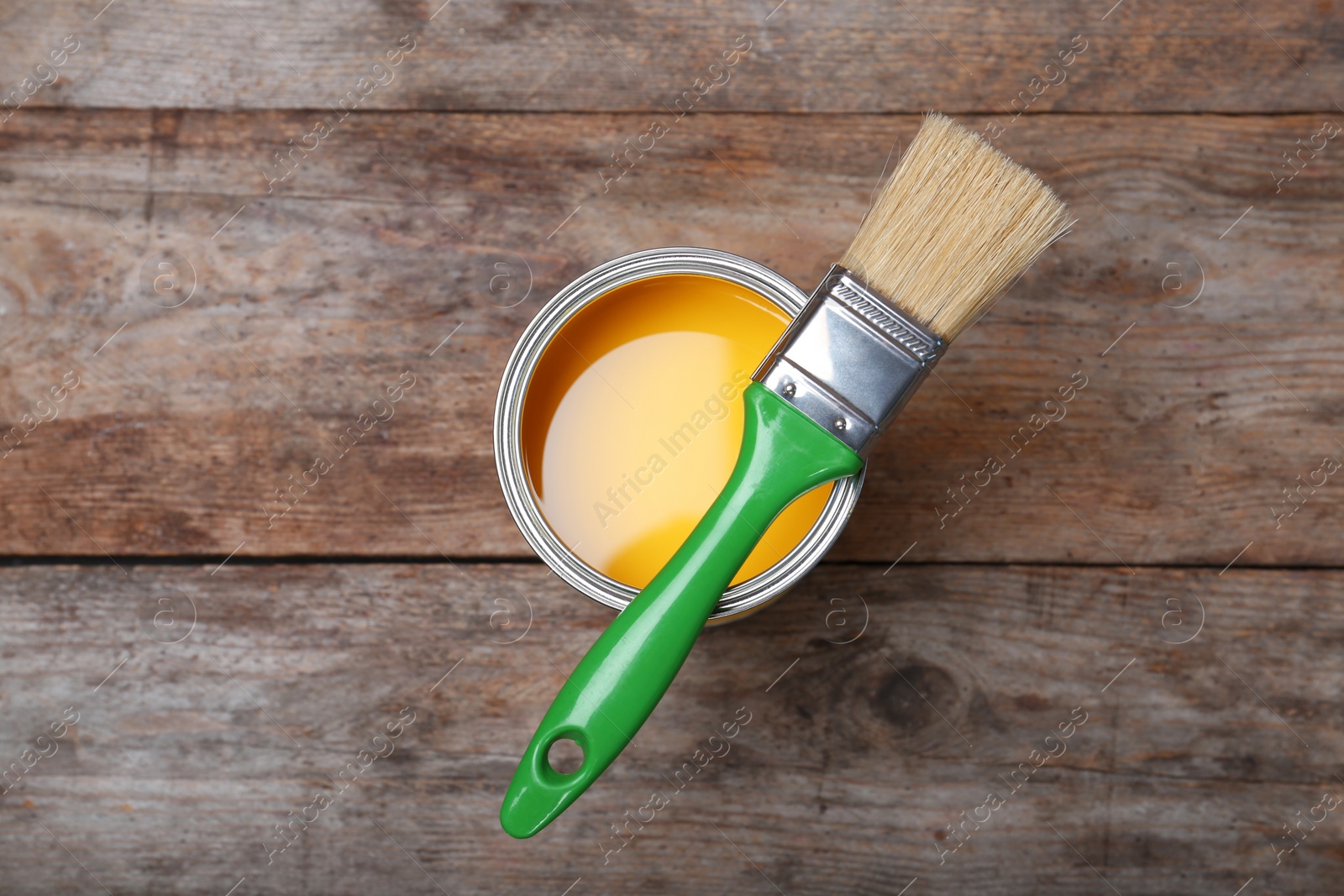 Photo of Paint can and brush on wooden background, top view