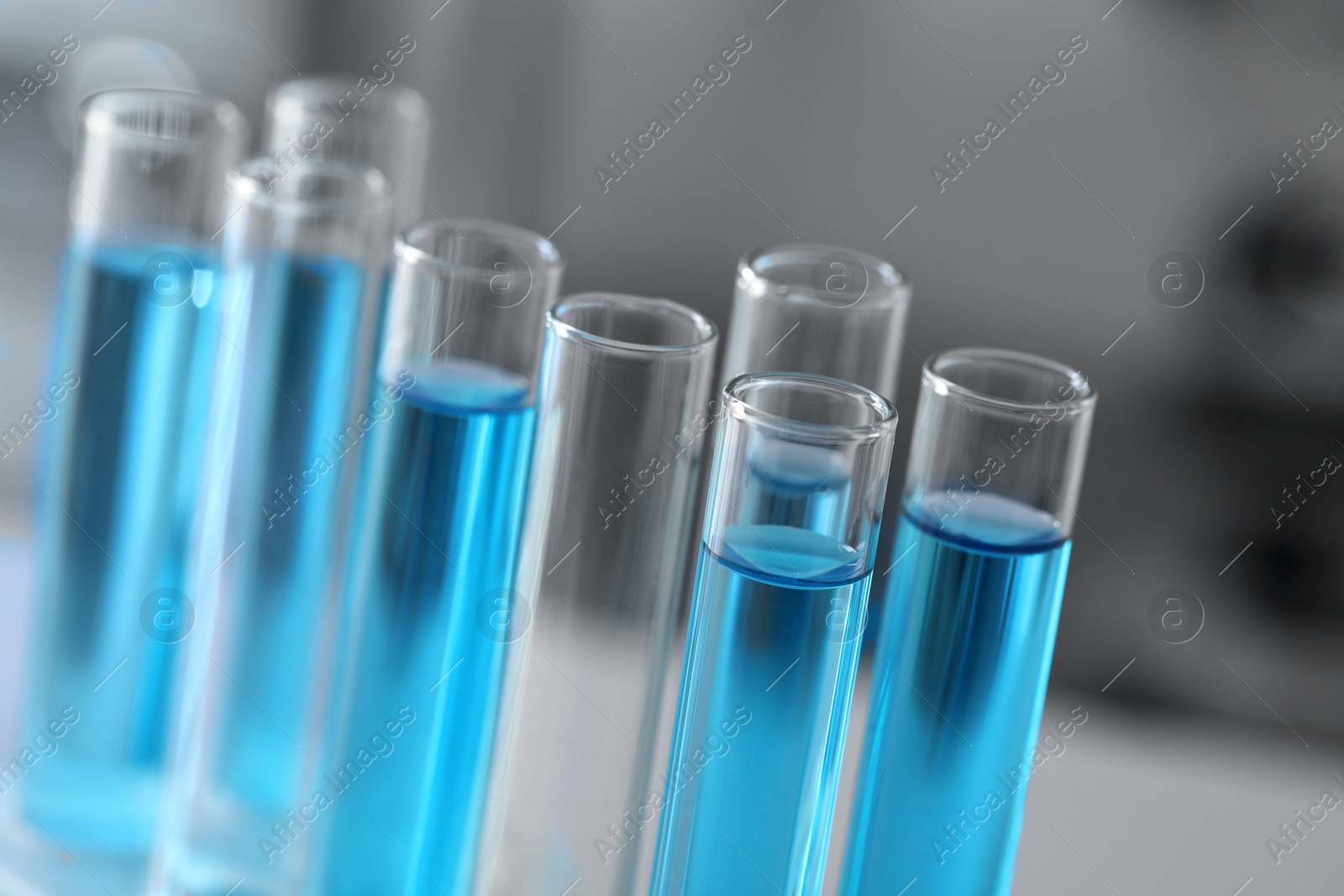 Photo of Test tubes with light blue liquid in laboratory, closeup