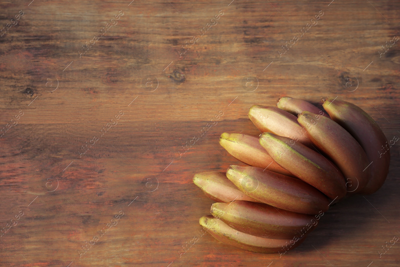 Photo of Tasty purple bananas on wooden table, top view. Space for text