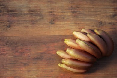 Photo of Tasty purple bananas on wooden table, top view. Space for text