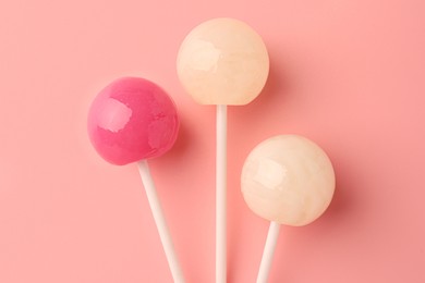 Tasty lollipops on pink background, flat lay