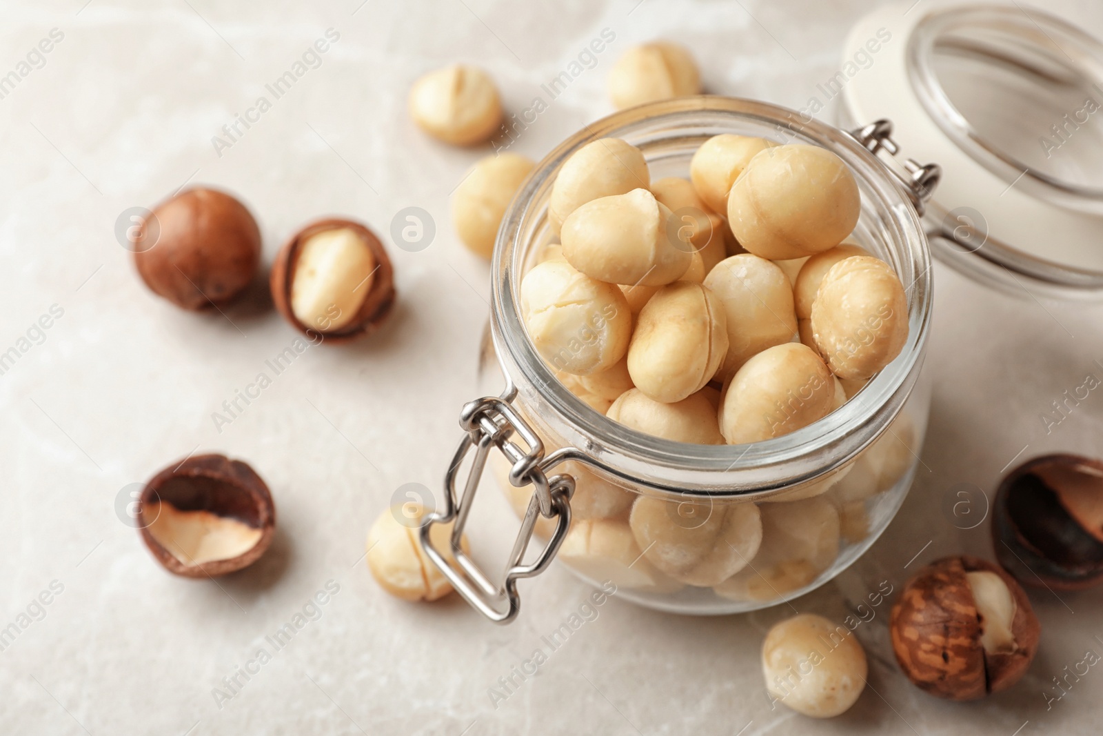 Photo of Jar with shelled organic Macadamia nuts and space for text on light table