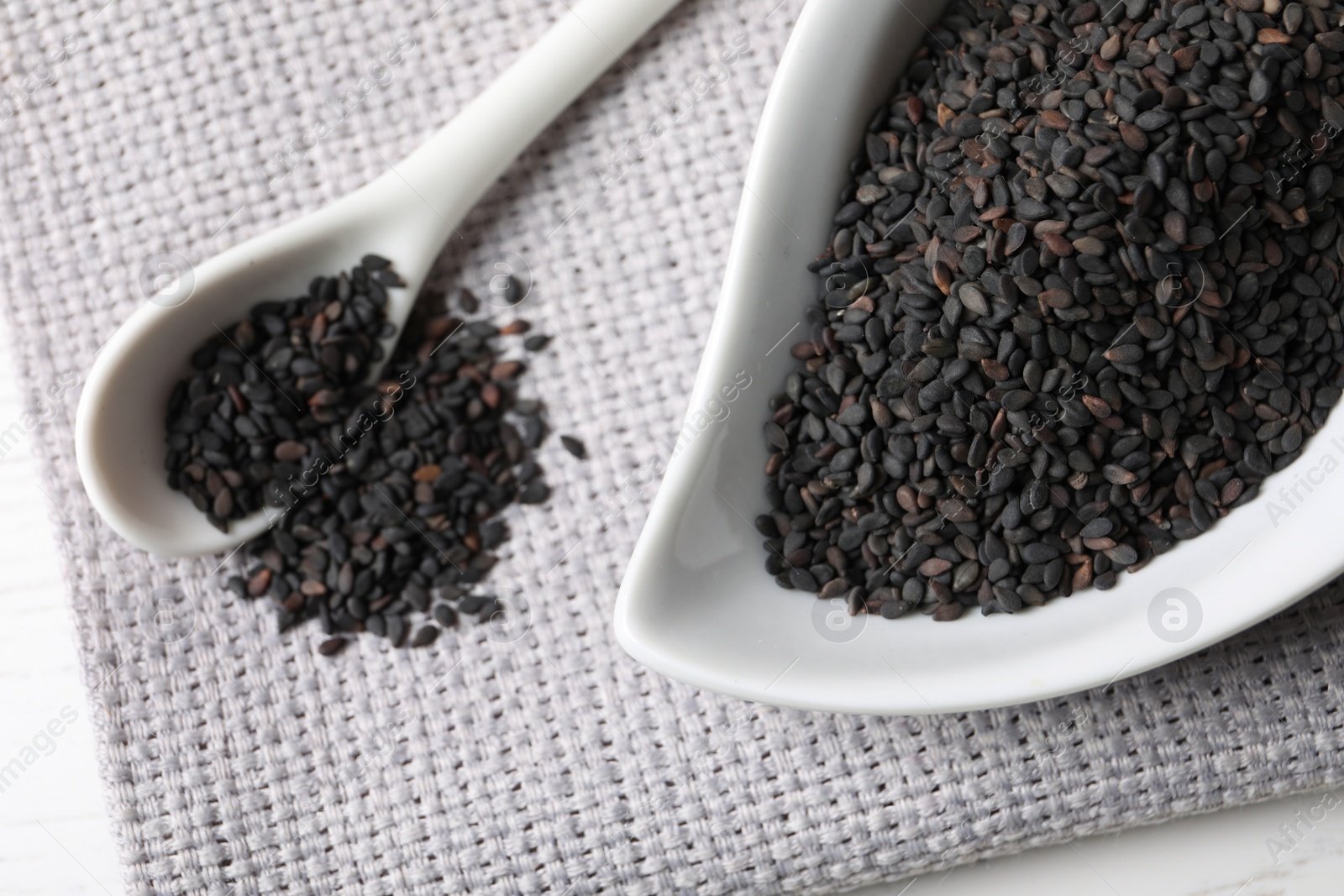 Photo of Black sesame seeds on white table, closeup view