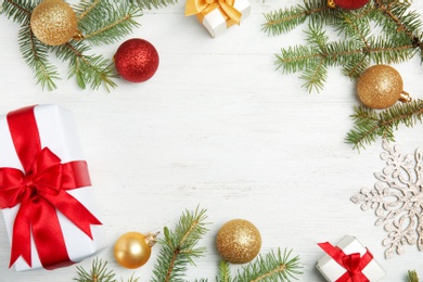 Flat lay composition with Christmas tree branches and festive decor on wooden background