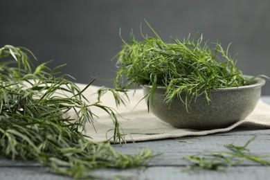 Photo of Fresh tarragon leaves on grey wooden table