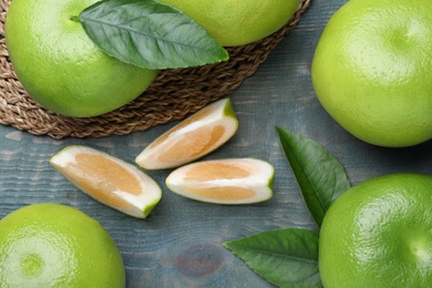 Photo of Fresh ripe sweetie fruits on blue wooden table, flat lay