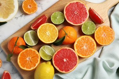 Photo of Different citrus fruits on marble background, top view