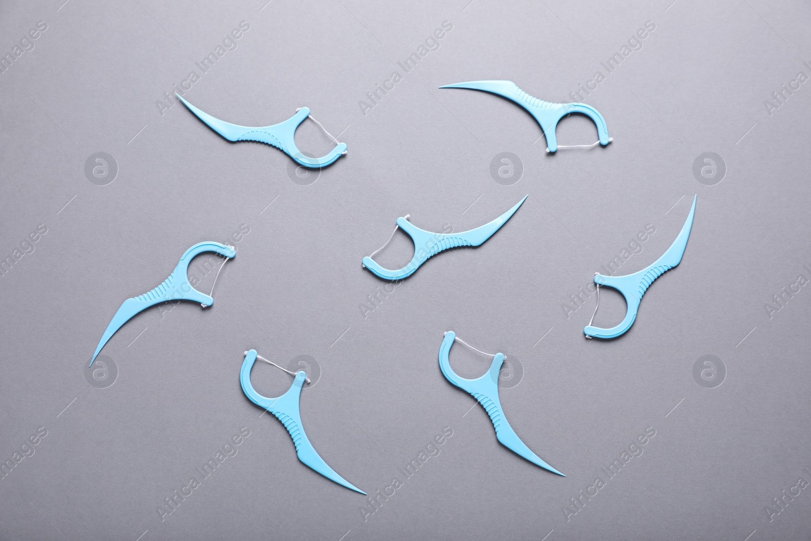 Photo of Flat lay composition with dental floss picks on grey background