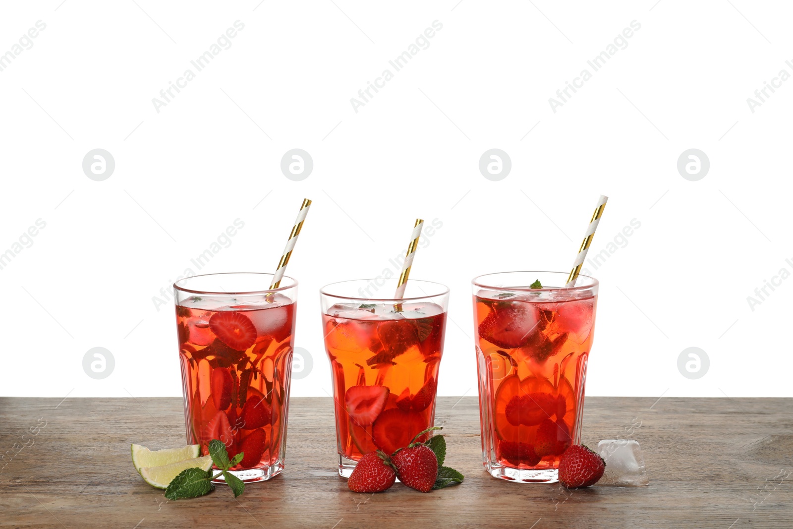 Photo of Refreshing drink with strawberry and lime on wooden table