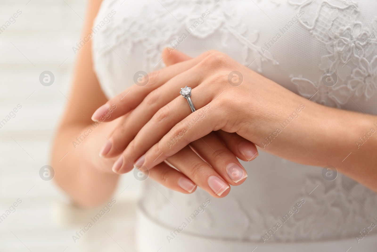 Photo of Young bride wearing beautiful engagement ring, closeup