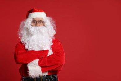 Photo of Merry Christmas. Santa Claus posing on red background, space for text