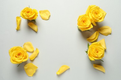 Photo of Frame made of beautiful yellow roses on light grey background, flat lay. Space for text