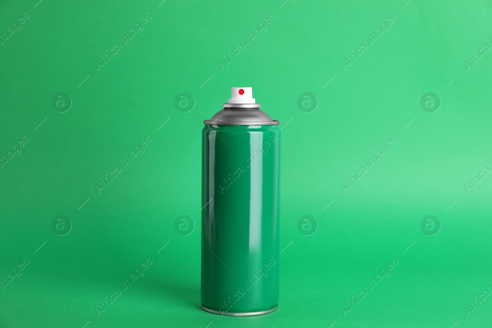 Photo of Colorful can of spray paint on green background