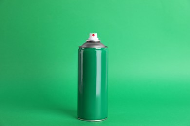 Photo of Colorful can of spray paint on green background