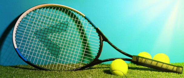 Image of Tennis racket and balls on green grass against light blue background, space for text. Banner design