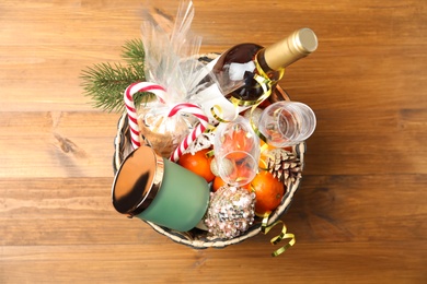 Photo of Basket with Christmas gift set on wooden table, top view