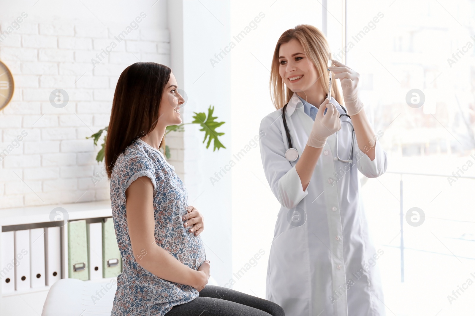 Photo of Doctor vaccinating pregnant woman in clinic