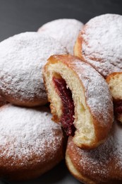 Photo of Delicious sweet buns with jam and powdered sugar, closeup