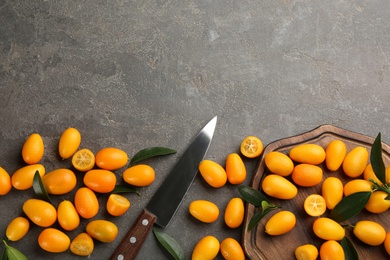 Photo of Fresh ripe kumquats on grey table, flat lay. Space for text