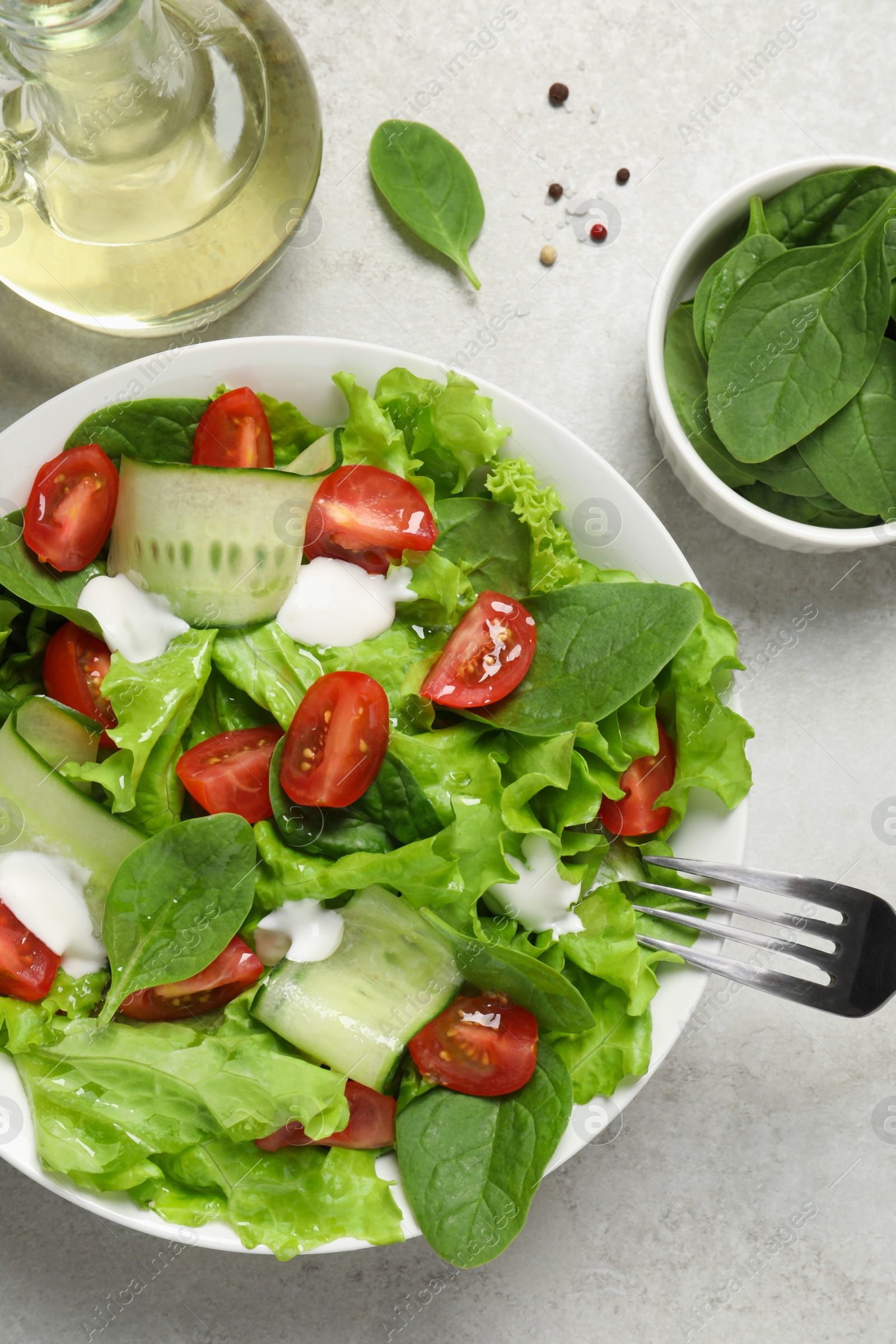 Photo of Delicious vegetable salad served on light grey table, flat lay