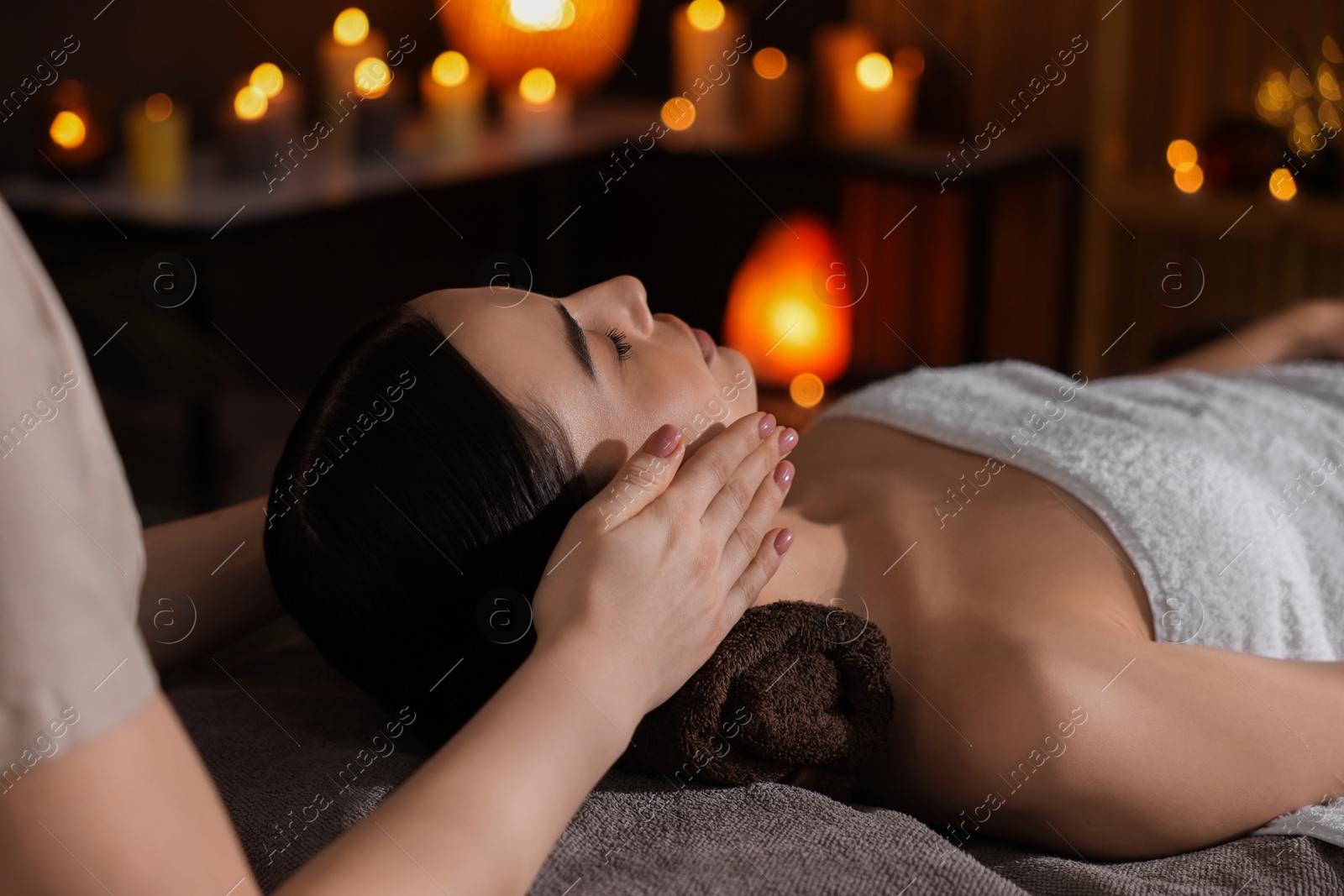 Photo of Spa therapy. Beautiful young woman lying on table during massage in salon