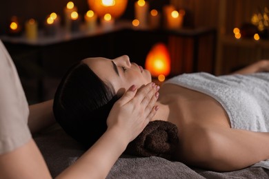 Photo of Spa therapy. Beautiful young woman lying on table during massage in salon